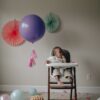 girl in white shirt lying on white and pink high chair